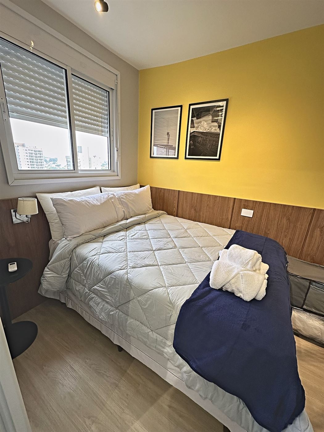 Quarto de casal com enxoval branco e manta azul