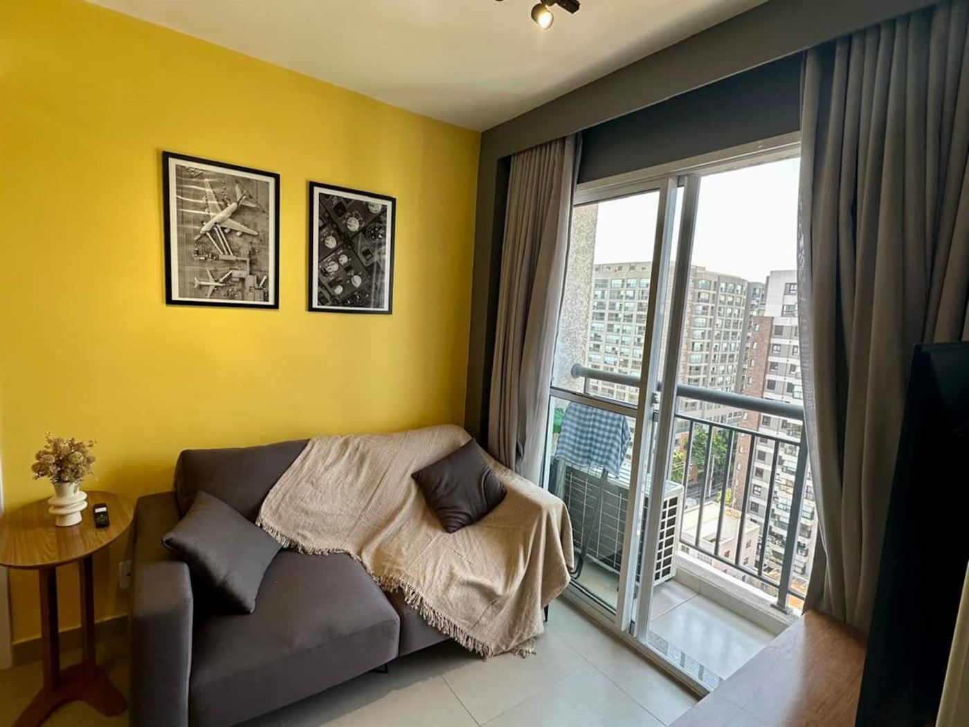 Sala de estar com sofá, manta e vista pela janela